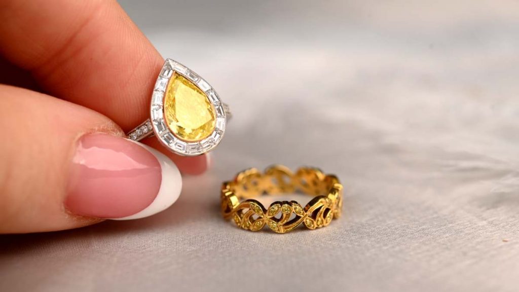 Model holding yellow diamond canary ring with filigree canary diamond band