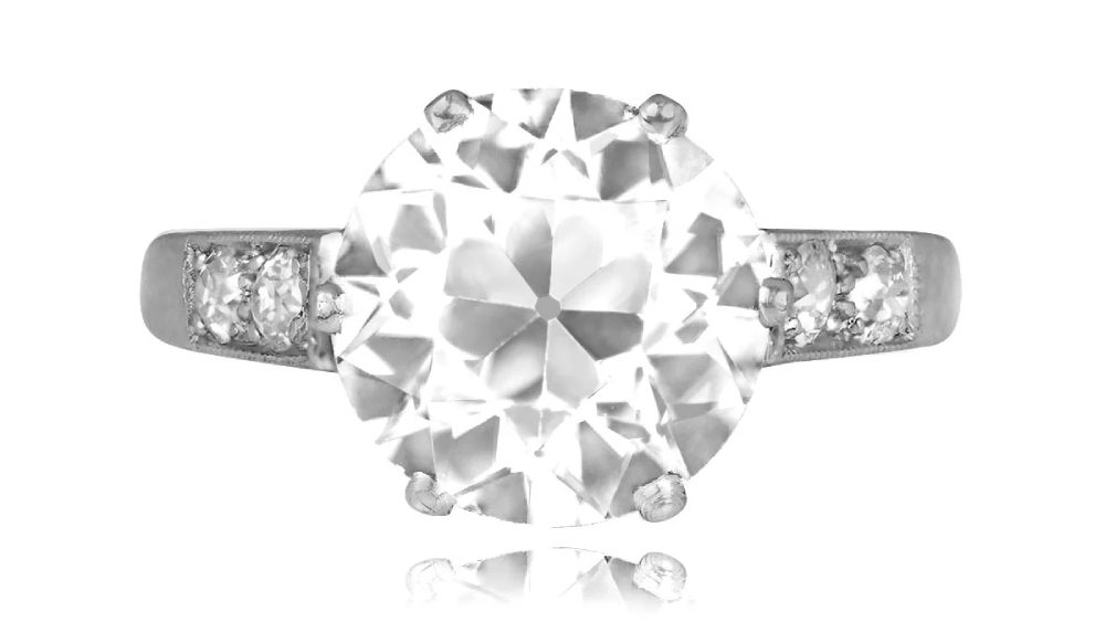 A six prong diamond ring with white gold and shoulder diamonds.