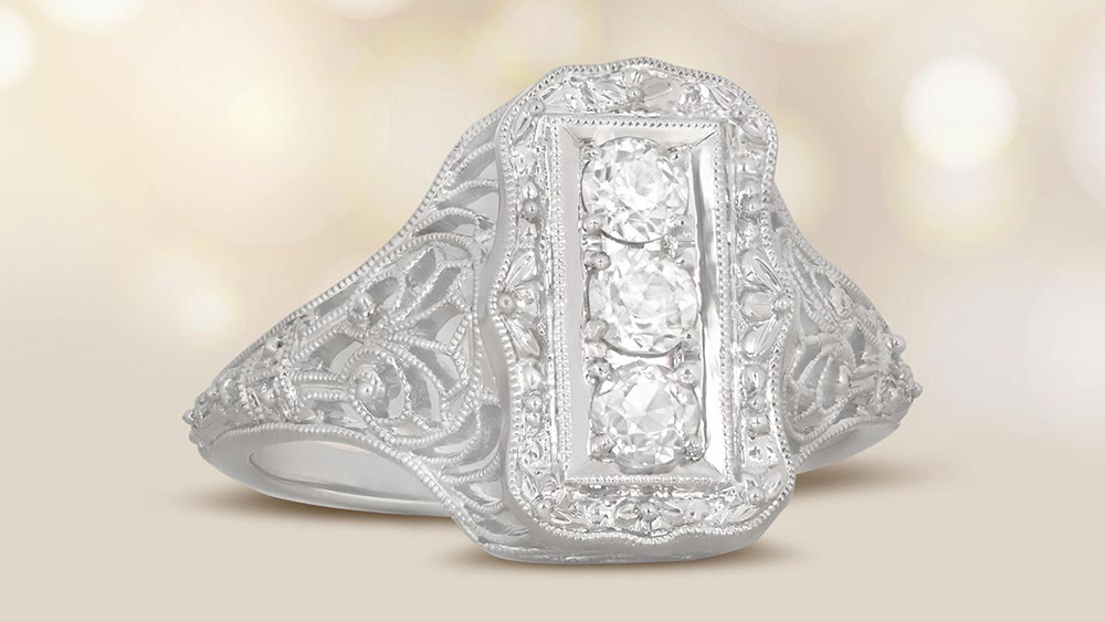 three stone platinum ring with 3 old European cut diamonds in a vertical stack