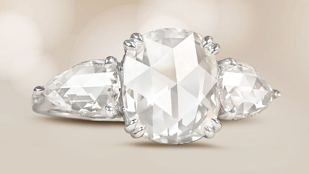 three stone platinum ring with rose cut center diamond and pear shaped side diamonds