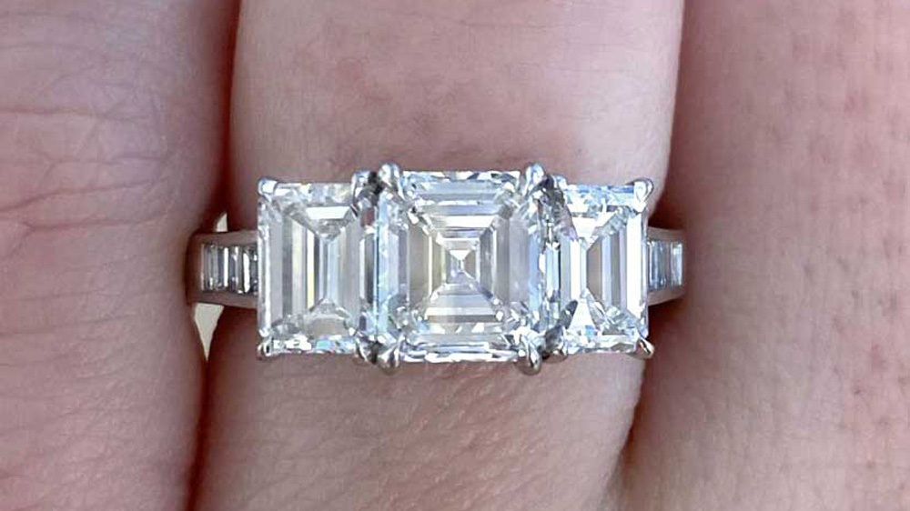 three stone ring set in platinum with asscher cut center diamond and emerald cut side diamonds