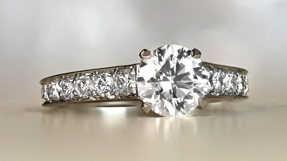 A solitaire diamond ring with accent diamonds along the shoulders.