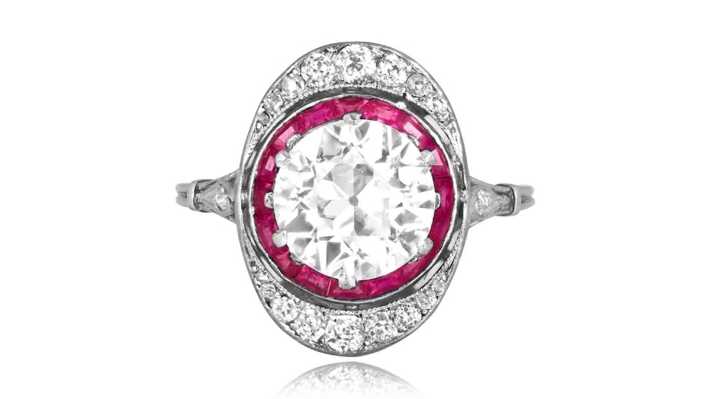 A large ruby halo ring with an elevated diamond.