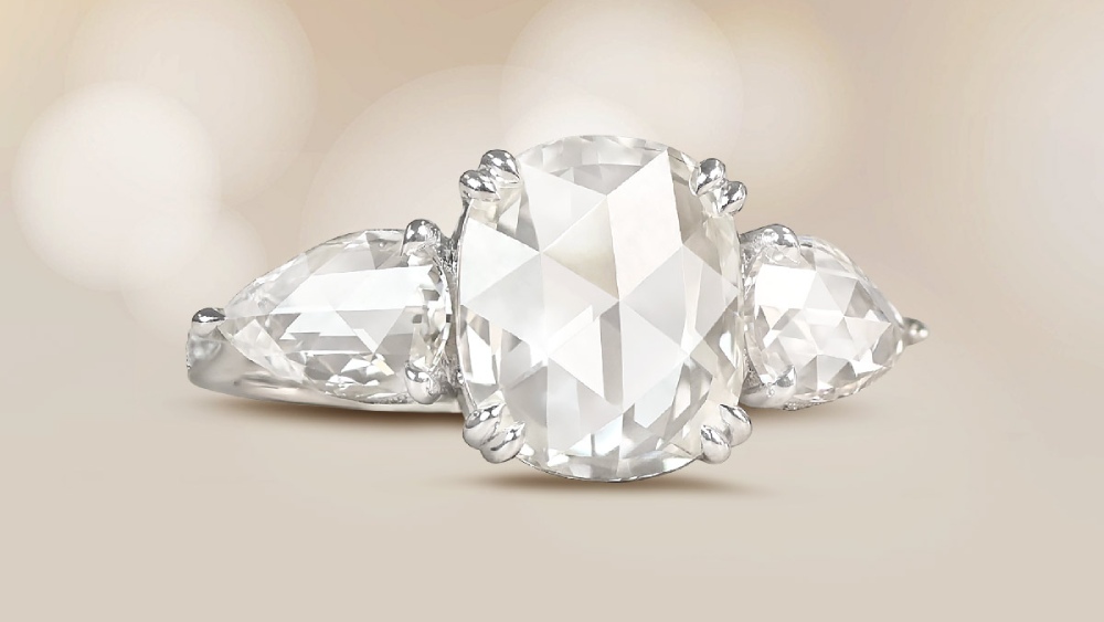 A three-stone ring featuring a rose cut and two pear shape diamonds.