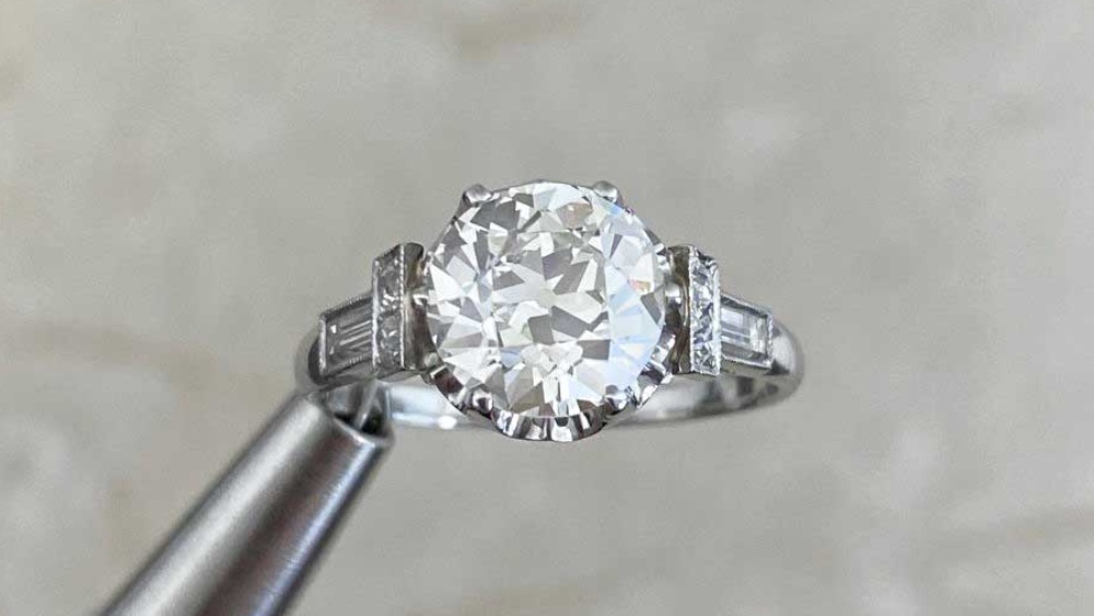 A solitaire diamond ring with three diamonds on each shoulder.