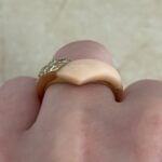 van cleef and arpels ring featuring a section of angel skin coral and round brilliant cut diamonds