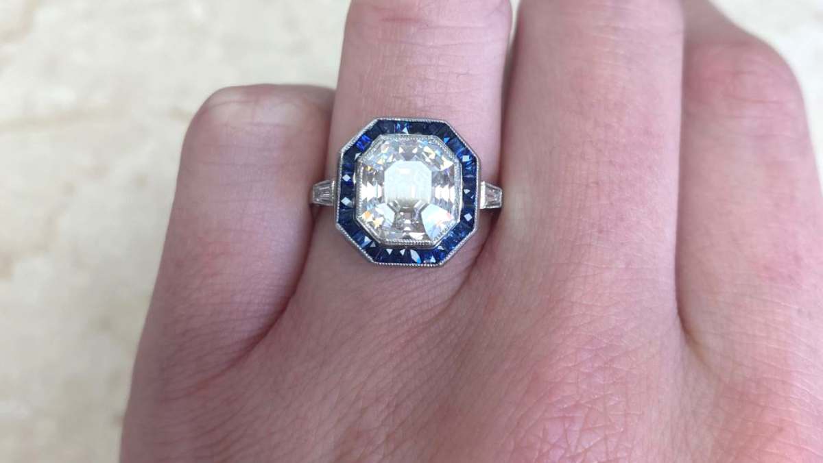 center 4.09 carat asscher diamond with French cut sapphire halo