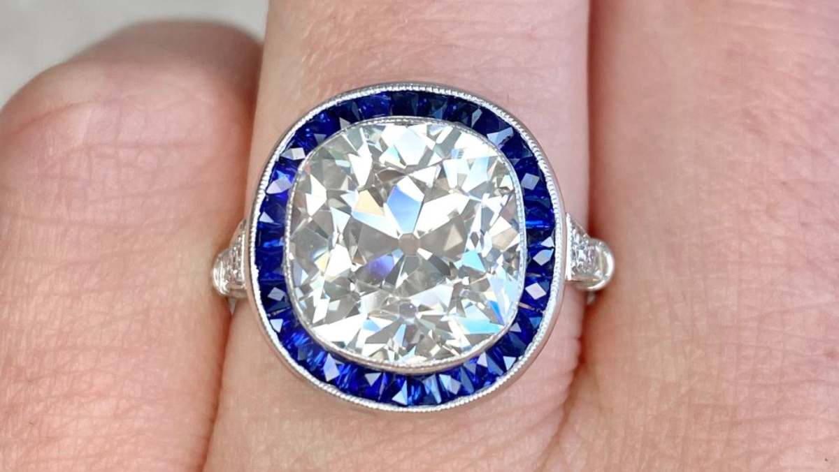 engagement ring featuring a very large diamond surrounded by a sapphire halo