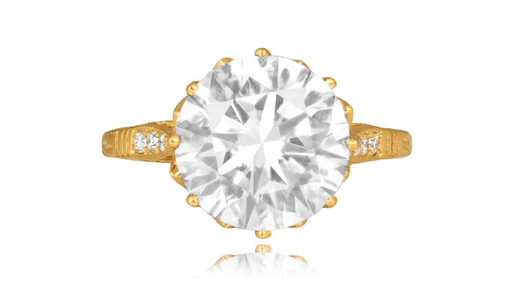 A yellow gold solitaire diamond ring with shoulder diamonds.