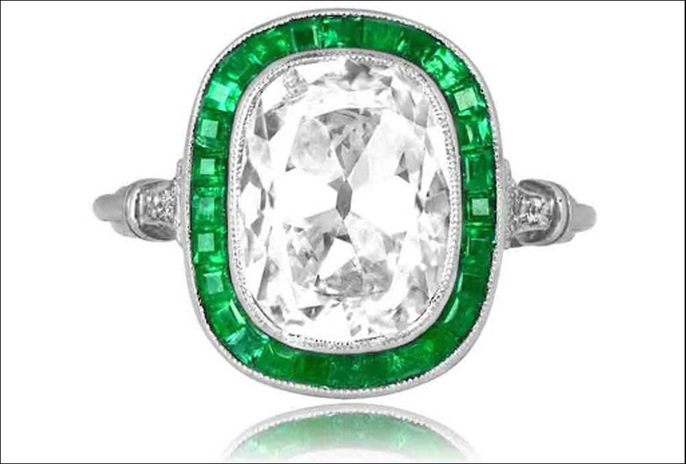 cushion cut diamond ring with an emerald halo set in platinum