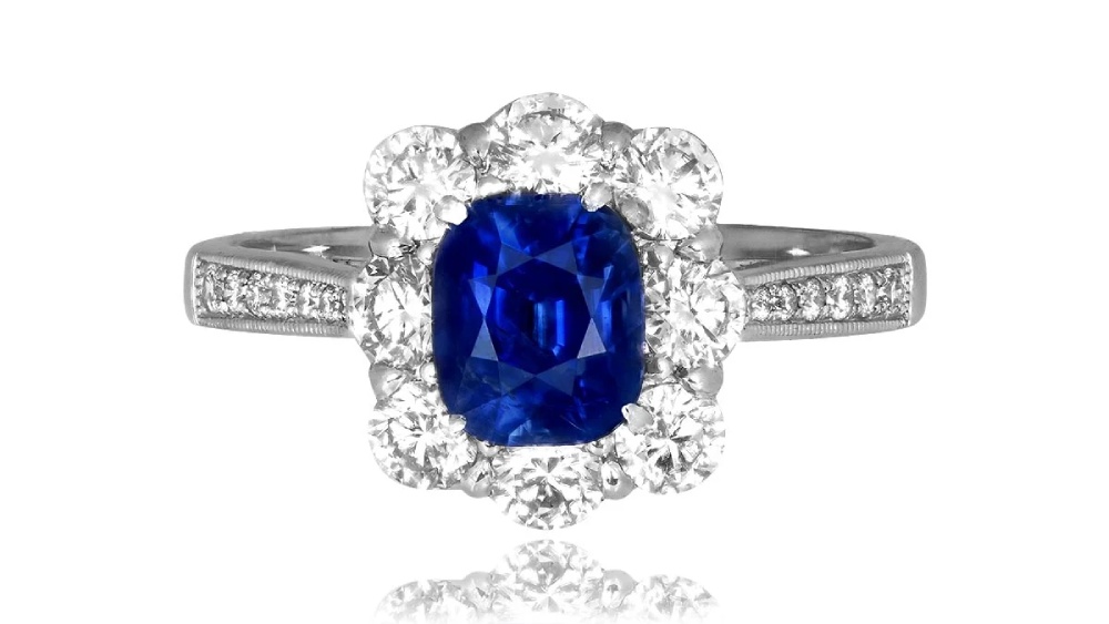 A deep blue sapphire ring with a cluster of eight diamonds.