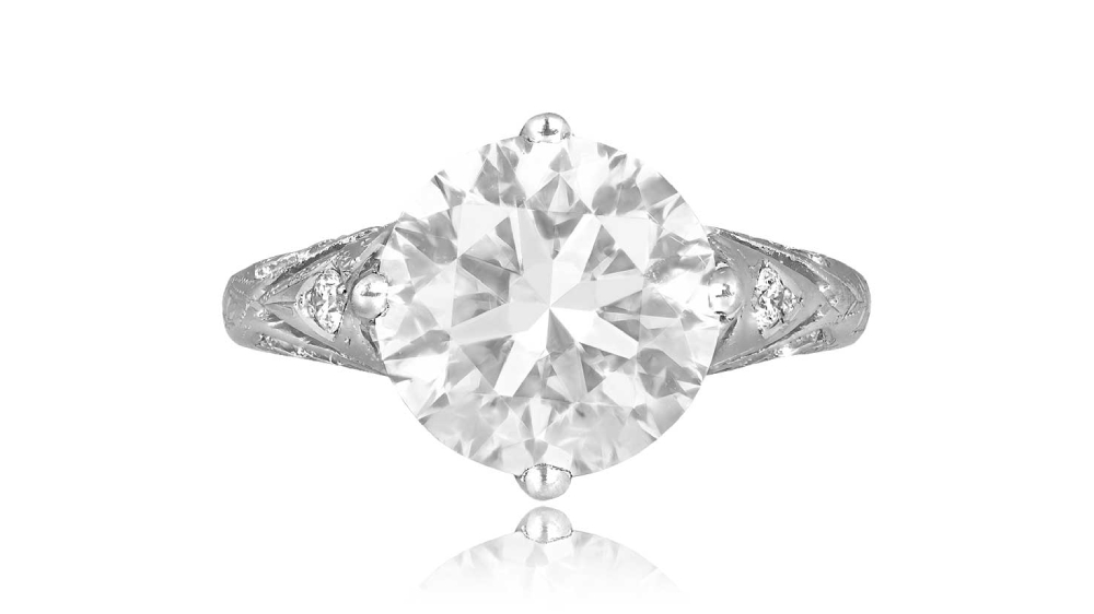A solitaire diamond ring with openwork and diamonds on the shoulders.