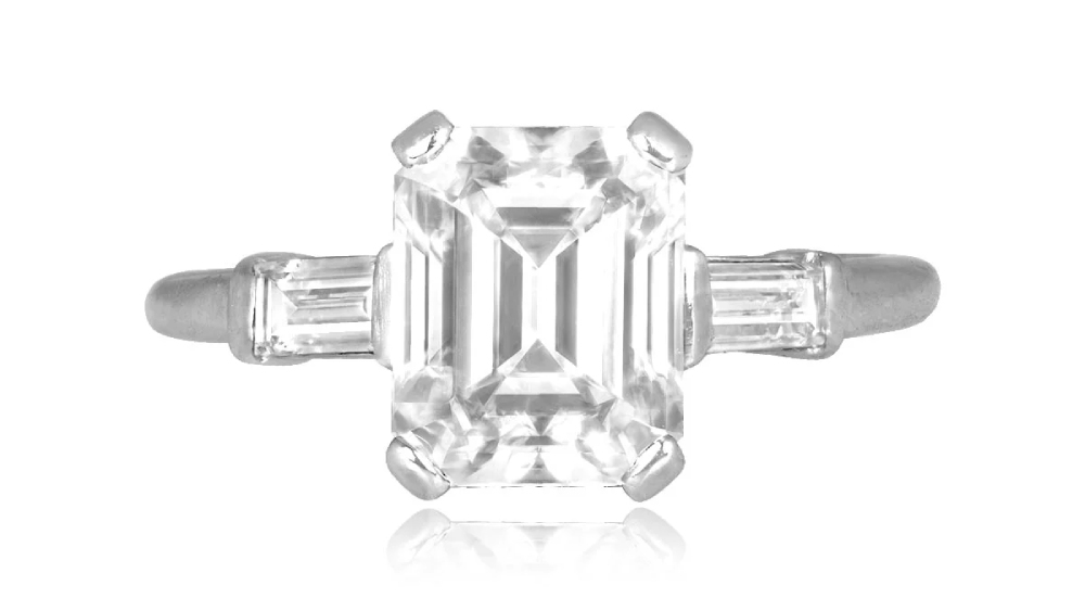 An emerald-cut diamond ring with baguette diamond shoulders.