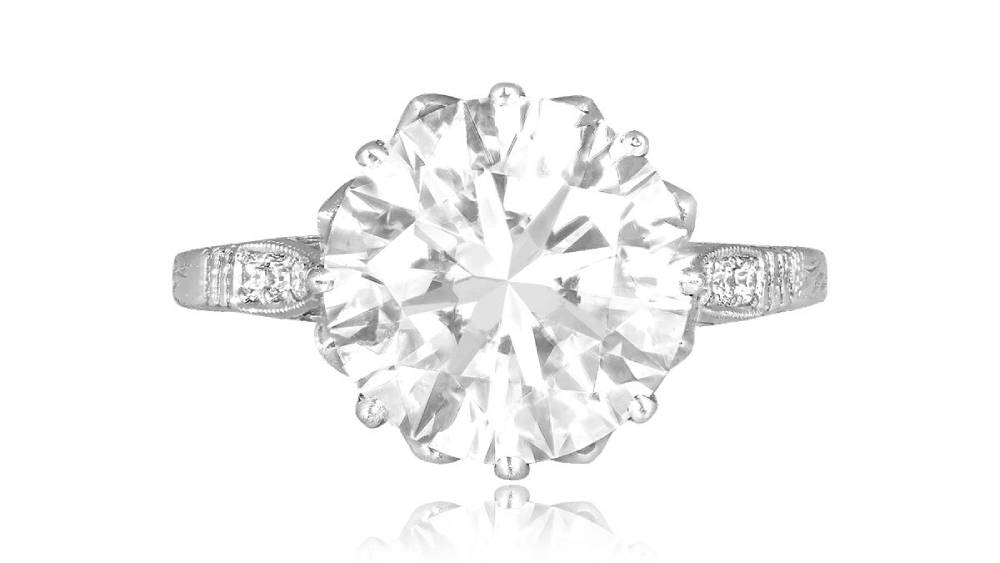 A solitaire diamond ring with delicate embellished shoulders.