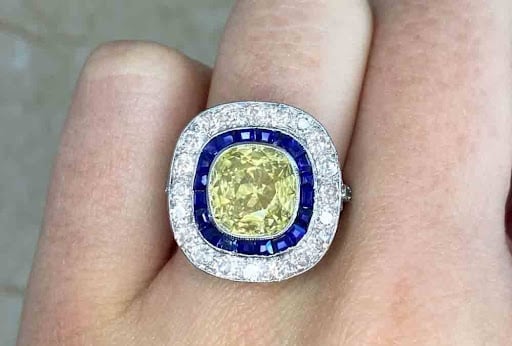 fancy yellow diamond ring with a double halo of sapphires and diamonds in platinum