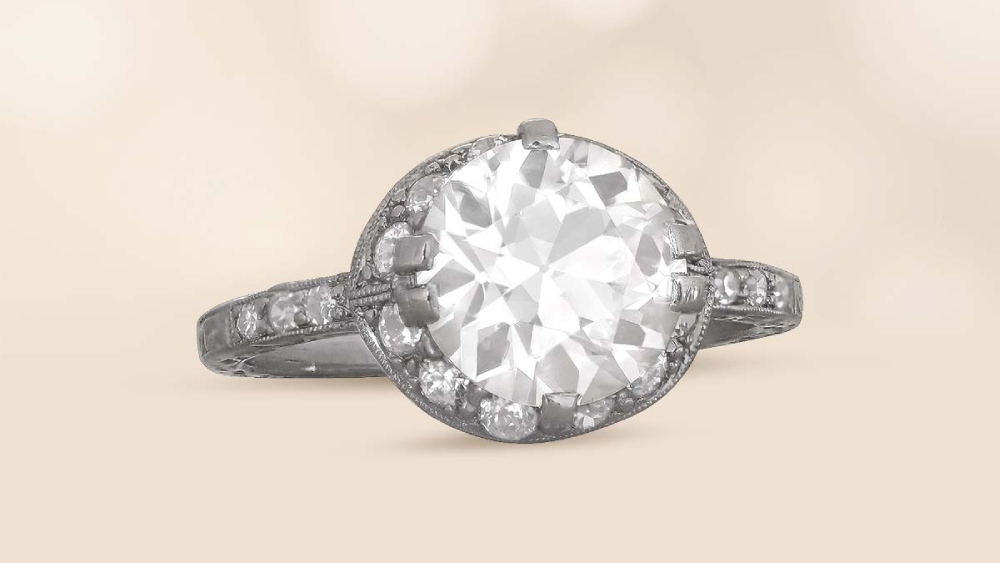 A diamond ring with a low halo of diamonds.