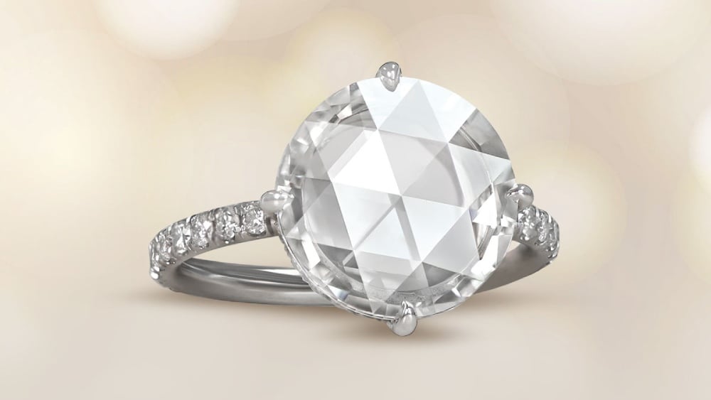 A solitaire diamond ring with pave diamond shoulders.