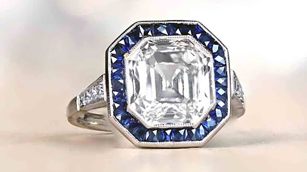 asscher cut diamond with a sapphire halo
