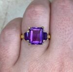 zima ring featuring an emerald-cut amethyst center