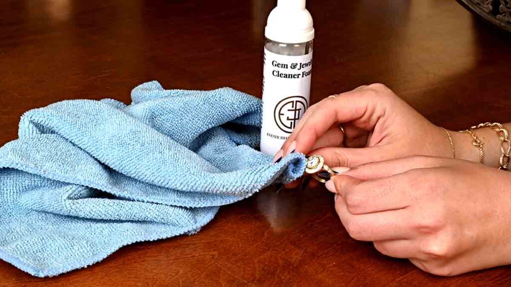 Cleaning a yellow gold diamond engagement ring with cloth and soap