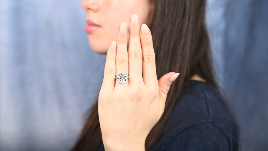 10 carat round modern natural diamond engagement ring on finger of model