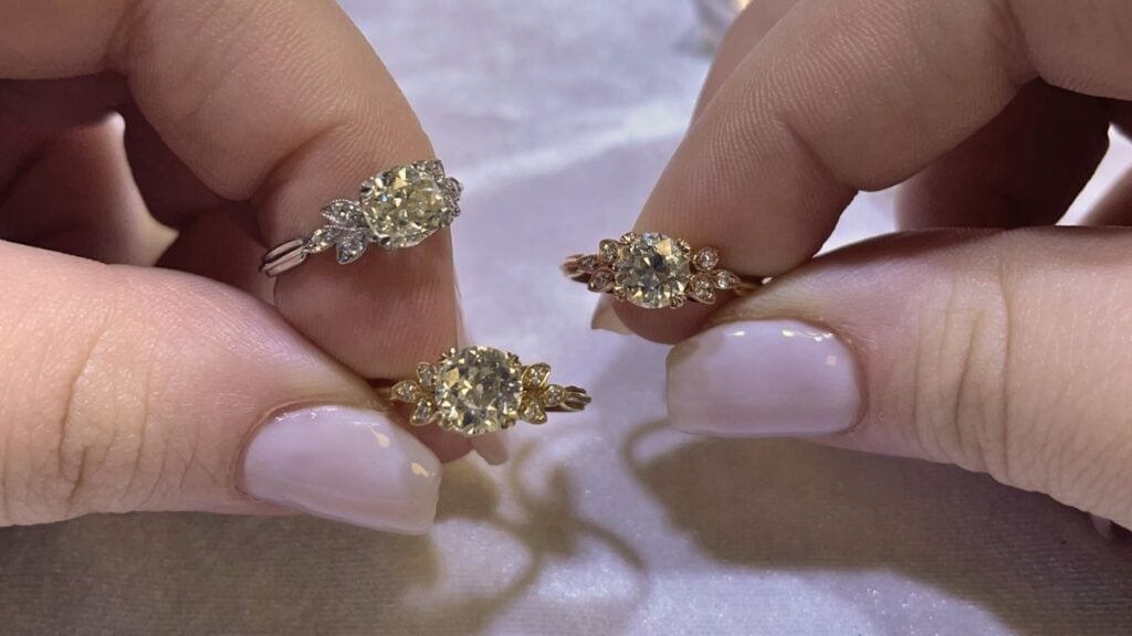 Jeweler holding white rose yellow gold engagement rings