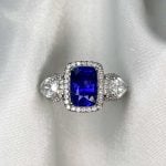 Prong-Set 1.70 carat sapphire center with diamond halo white backdrop f5 15694
