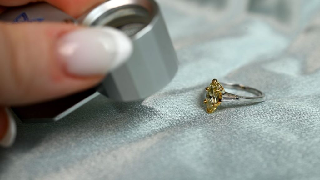 Jeweler Examining Yellow Marquise Cut Diamond Ring