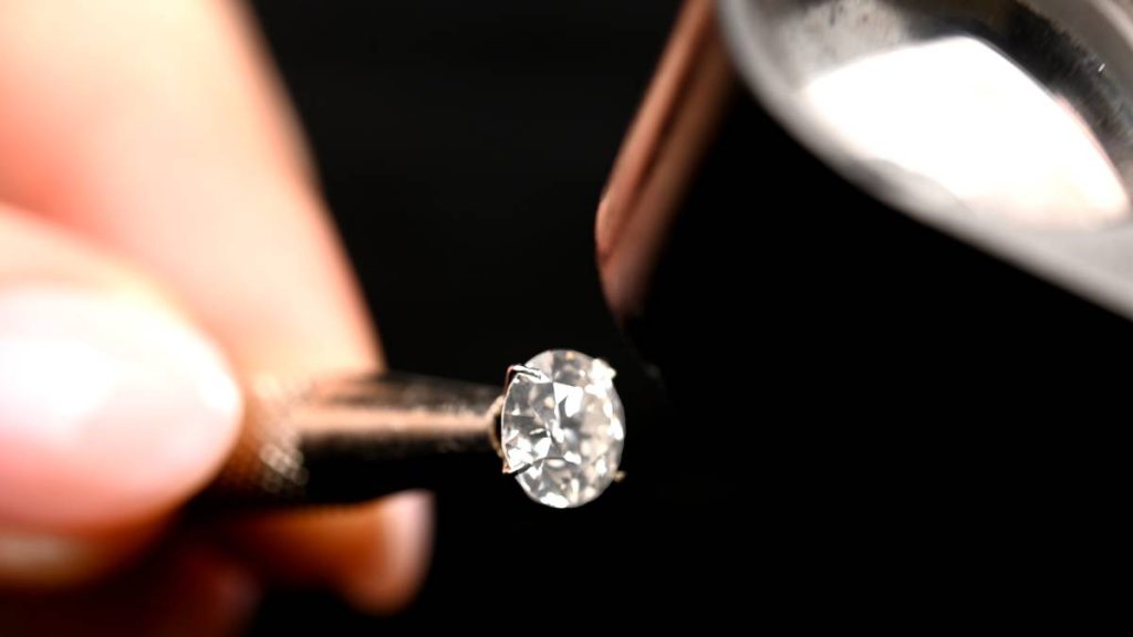 Close up examining a loose diamond with loupe