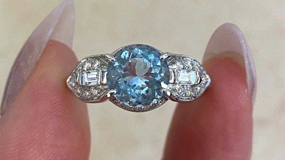 Retro era ring with an aquamarine stone set in platinum with additional baguette cut and single cut diamonds