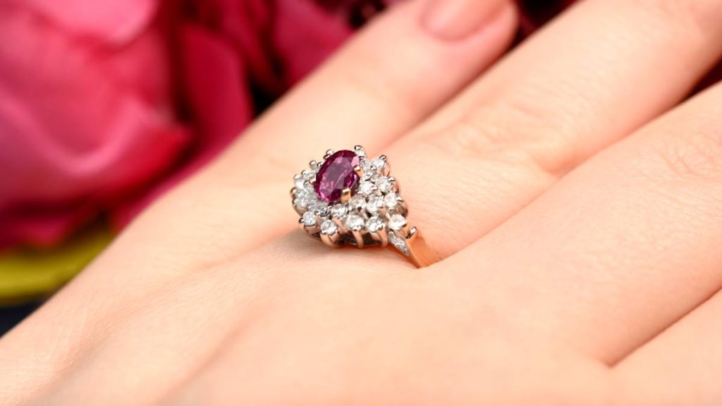 Tourmaline October and Diamond Cocktail Ring on finger with flowers in bg