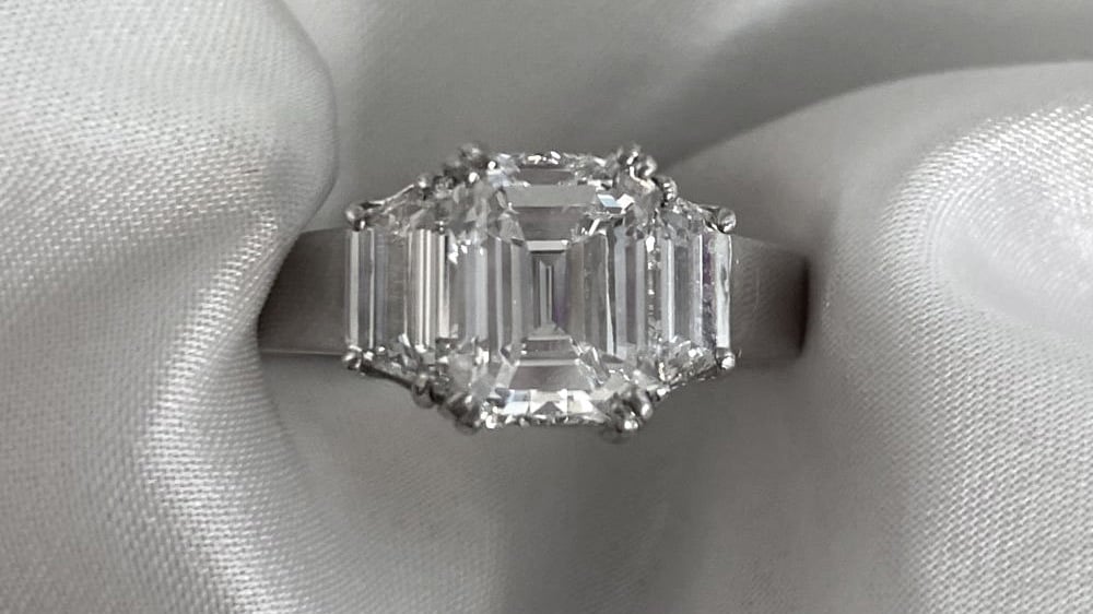 A platinum ring featuring a high-quality emerald cut diamond.