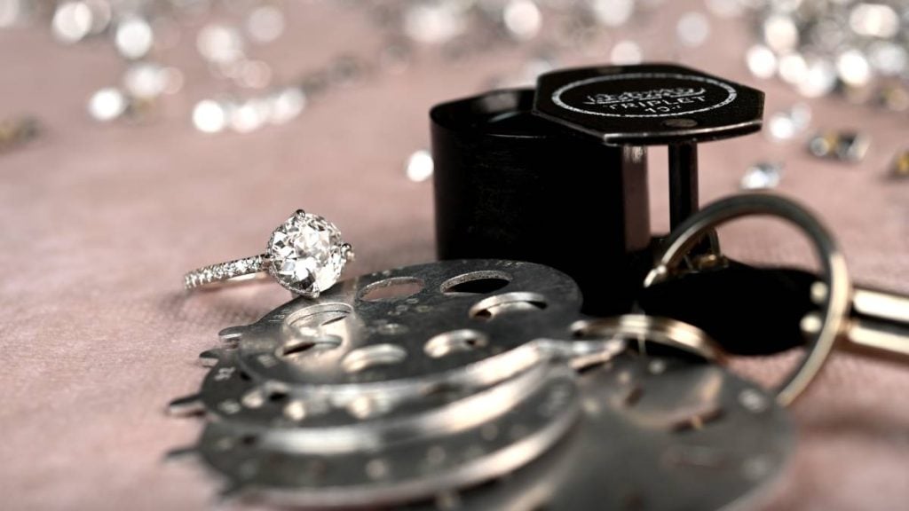 Vintage diamond engagement ring with jewelry tools in office