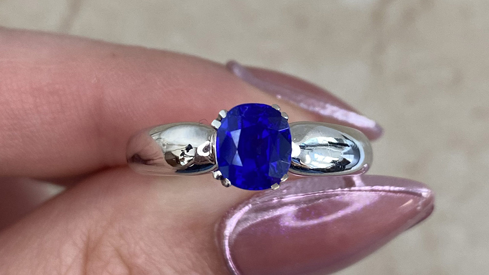 A delicate white gold ring with a sapphire in double prongs.
