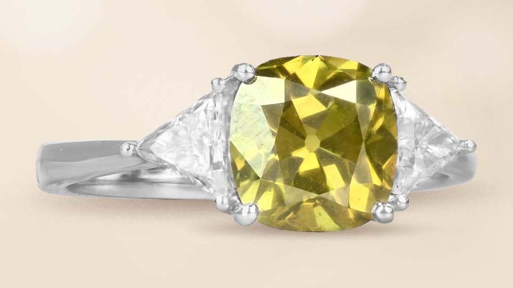 green chameleon cushion cut diamond with trillion cut side diamonds in 18k white gold