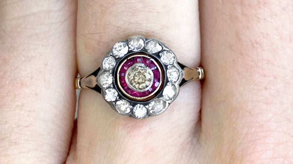 Victorian era ring featuring an old mine cut diamond with ruby and diamond halos