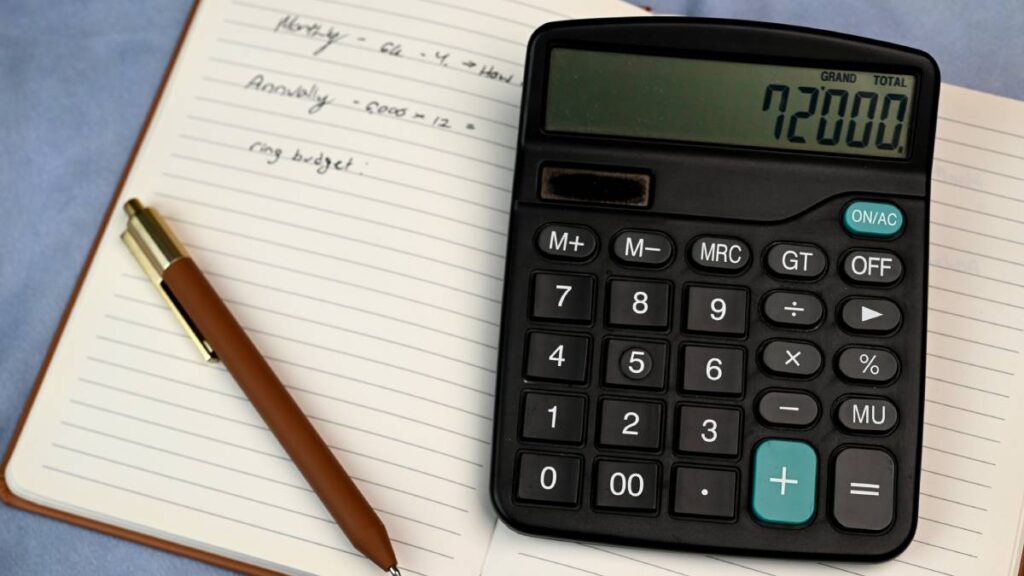 Planning engagement ring budget with pen paper calculator