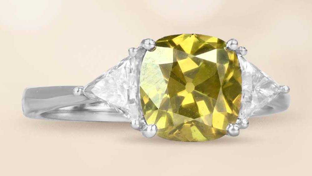 green chameleon cushion cut diamond with trillion cut side diamonds in 18k white gold